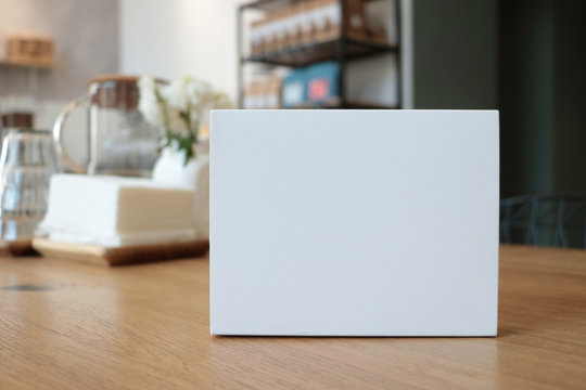 On the table is a white box suitable for mockup. Empty white background for design. White notebook. White paper. without text. Coffee house. Cafe background. notepad. Stylish modern photo