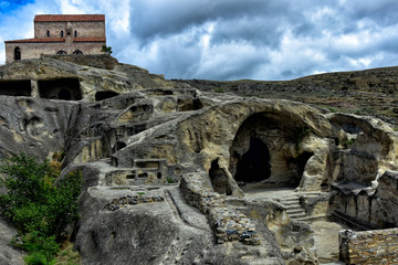 Tourists on an excursion in the ancient caves. The ancient cave city of Uplistsikhe in Asia, Georgia