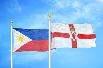 Philippines and Northern Ireland two flags on flagpoles and blue cloudy sky