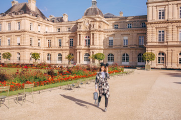 Obraz premium Happy girl in a mikimaus hat in the Luxembourg garden and the Palace in Paris.