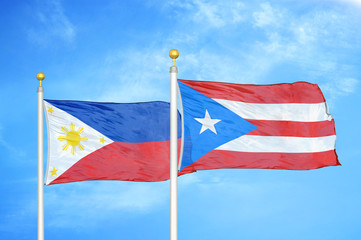 Philippines and Puerto Rico two flags on flagpoles and blue cloudy sky