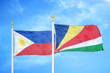Philippines and Seychelles two flags on flagpoles and blue cloudy sky