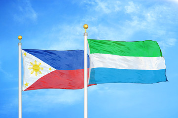 Philippines and Sierra Leone two flags on flagpoles and blue cloudy sky