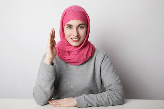 Close-up portrait of a muslim young woman wearing a hijab and putting hand up. Women rights concept.
