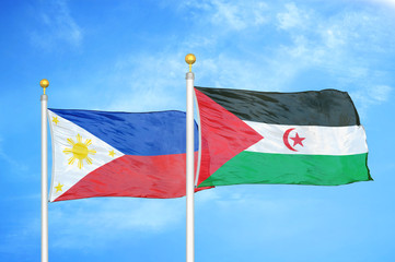 Philippines and Western Sahara two flags on flagpoles and blue cloudy sky