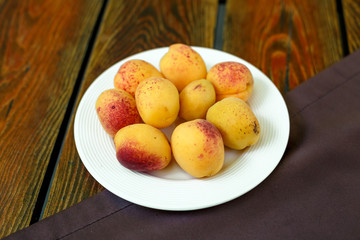 apricots in a plate on a wooden table