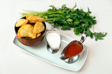 Pastry with greens and sacks on a wooden surface