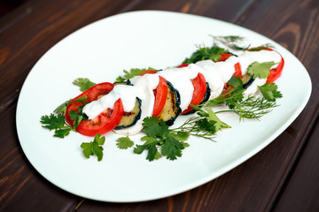 fried eggplant with tomatoes and greens under sauce with wine
