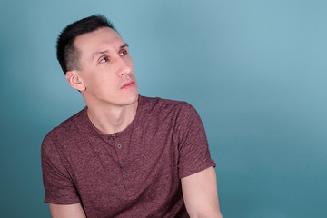 portrait of a young discontented man on a dark blue background who looks away. space for text and caption