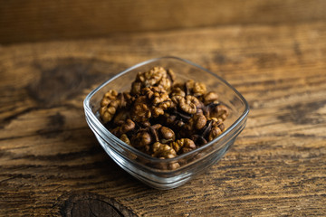 Walnut in a small plate on a vintage wooden table as a background. Walnuts is a healthy vegetarian protein nutritious food. Natural nuts snacks.