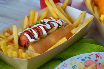 hot dog with French fries in a shipping container