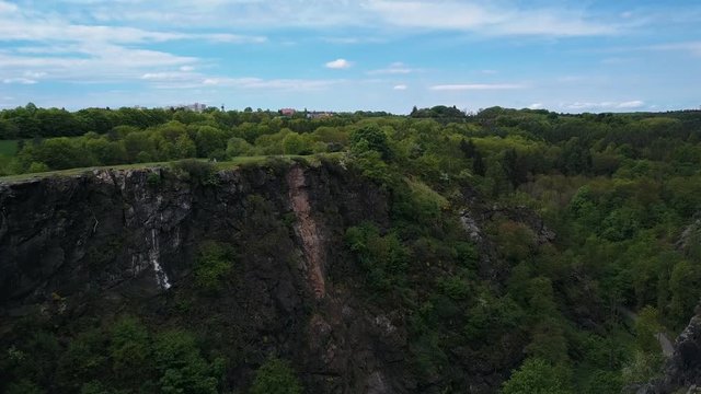 The camera approaches the Divok Sarka Canyon. Green park in spring, aerial shot.