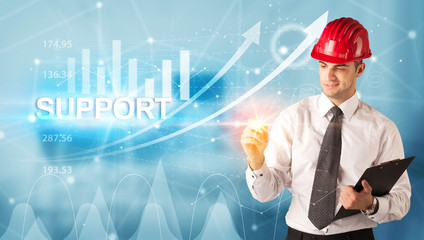 Young businessman with helmet drawing SUPPORT inscription, modern business technology concept