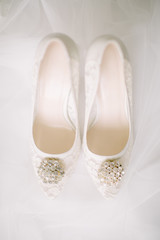 Bridal shoes on tulle. Gemstone and lace.