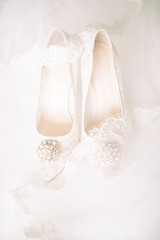 Fototapeta na wymiar Bridal shoes on tulle. Gemstone and lace.