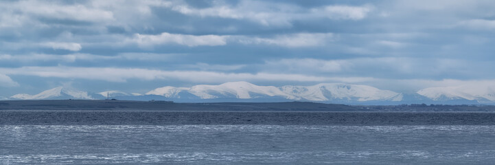 The Cairngorm Mountains in winter with snow on their peaks seen from Sutherland across the Moray Firth
