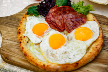 Bacon and eggs on a wheat cake with greens for lunch