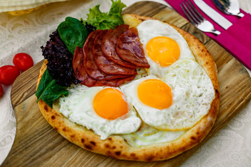 Bacon and eggs on a wheat cake with greens for lunch