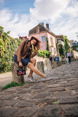 A beautiful young woman in a brown jacket walks in the early morning on the famous Montmartre hill...