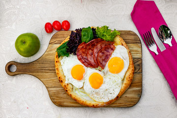 Bacon and eggs on a wheat cake with greens for lunch