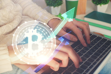 Double exposure of woman hands typing on computer and crypto market theme hologram drawing....