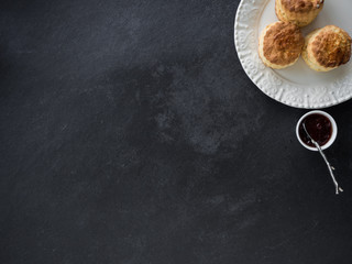 Freshly baked homemade scones with jam. slate background
