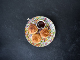 Freshly baked homemade scones with jam. slate background