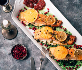 fried fish fillet with lemon slice and pomegranate
