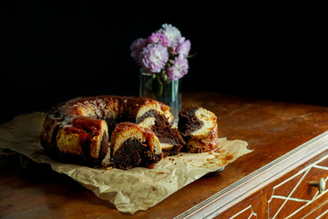 chocolate flan, Mexican chocoflan, chocolate biscuit cake and caramel custard pudding with a caramel sauce on top, on te dark wooden table