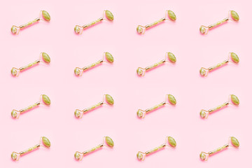 Seamless pattern. Massage roller for face with two jade stone on pink background. Skin care...