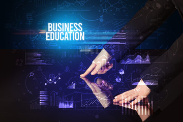 Businessman touching huge screen with BUSINESS EDUCATION inscription, cyber business concept
