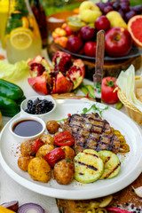 BBQ, juicy steak with grilled vegetables and sauce on a white plate