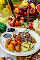 BBQ, juicy steak with grilled vegetables and sauce on a white plate