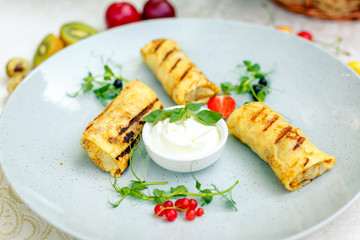 Pancakes with sour cream and berries on a decorated table for a holiday