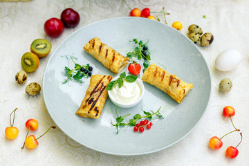 Fototapeta na wymiar Pancakes with sour cream and berries on a decorated table for a holiday