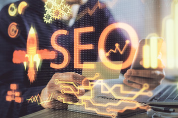 Multi exposure of man's hands holding and using a digital device and seo drawing. search...