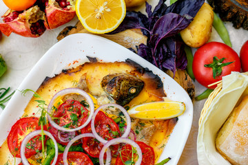 hot smoked fish koktal, Kazakh dish, with vegetables, tomatoes and onions on a festive table, special dish