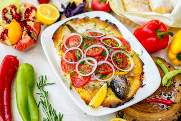 hot smoked fish koktal, Kazakh dish, with vegetables, tomatoes and onions on a festive table, special dish