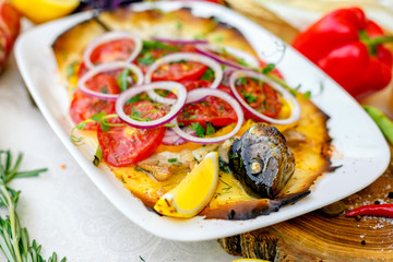 hot smoked fish koktal, Kazakh dish, with vegetables, tomatoes and onions on a festive table, special dish