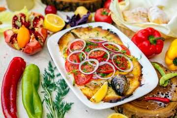 hot smoked fish koktal, Kazakh dish, with vegetables, tomatoes and onions on a festive table, special dish