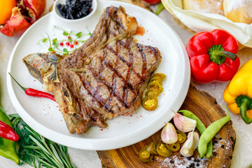 steak entrecote with pickled onions and jalapeno pepper on a white plate