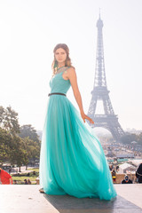 a girl in Paris in a green dress against the backdrop of the Eiffel tower elegant on the Trocadero...