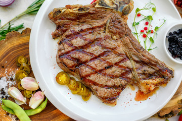 steak entrecote with pickled onions and jalapeno pepper on a white plate