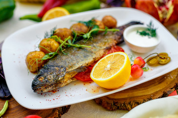 Grilled trout with potato sauce and tomato sauce and jalapeno