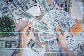 Multi exposure of financial graph drawing hologram and USA dollars bills and man hands. Analysis concept.