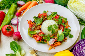 Thai meat with vegetables on a decorated table in a white plate