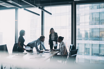 Male and female professionals teamworking during brainstorming cooperation on paper documents, group of diverse employers discussing corporate investment of firm capital briefing in conference room