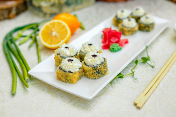 fried warm sushi with wasabi and soy sauce with chopsticks