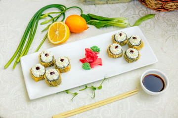 fried warm sushi with wasabi and soy sauce with chopsticks