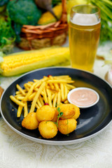 Fototapeta na wymiar Cheese balls with crispy fresh French fries with sauce on a decorated table